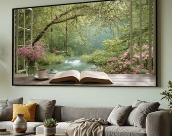 May include: A framed wall art print shows a tranquil outdoor scene. An open book, coffee cup, and vase of pink flowers are on a wooden surface. The view through the window reveals a river, swing, and verdant foliage.
