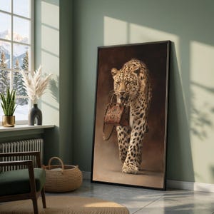 May include: A framed art print depicting a leopard walking, carrying a brown handbag. The leopard's coat is patterned with spots, set against a brown backdrop. The artwork is displayed in a room with a window showing a snowy mountain scene.