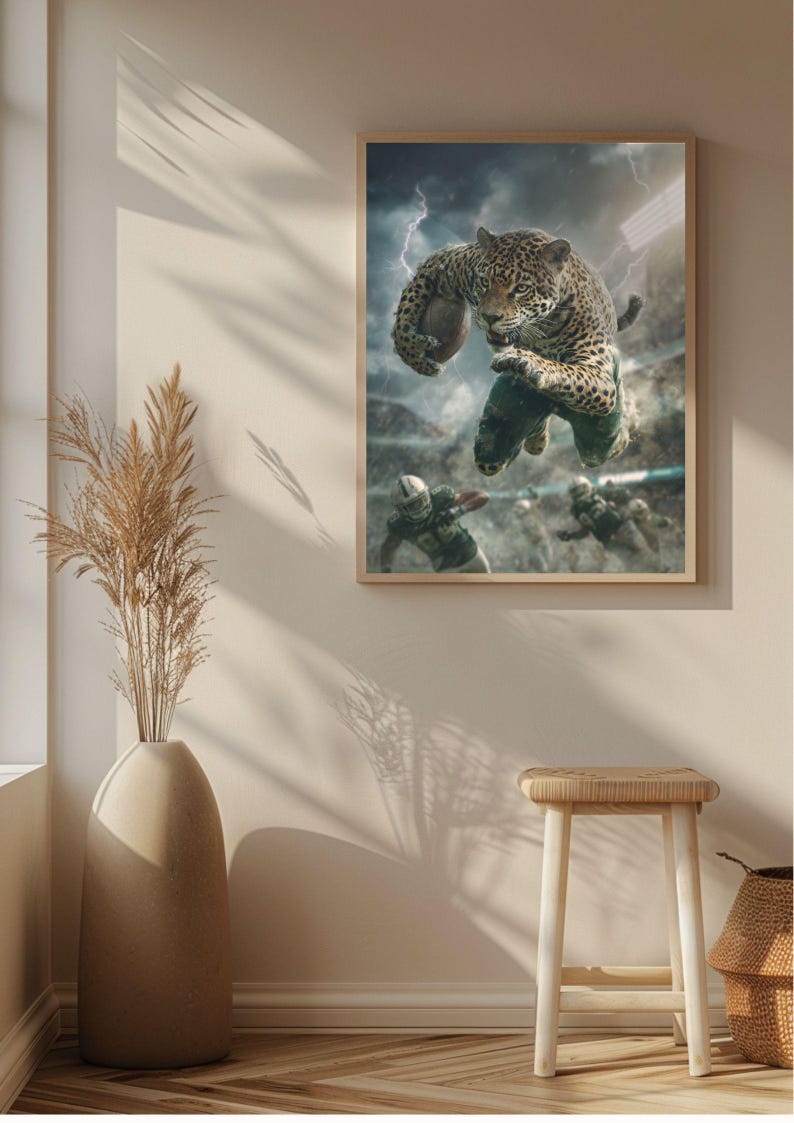 May include: A framed print shows a jaguar playing American football in a stadium during a storm. The jaguar, with its spotted coat, is leaping with the ball. Other players in green uniforms are visible in the background. The artwork is displayed on a wall.