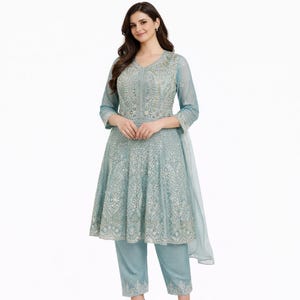 Puede incluir: Un traje Anarkali bordado en azul claro con pantalones a juego. El traje presenta intrincados detalles alrededor del escote, el corpiño y el dobladillo. El atuendo incluye un dupatta transparente, creando un look elegante y formal.
