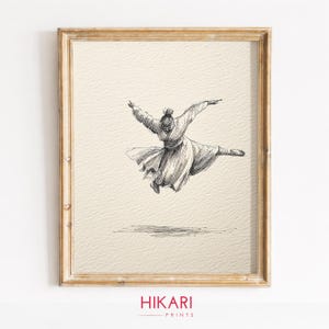 Peut inclure: Un croquis à l'encre noire et blanche sur papier texturé encadré, représentant une silhouette en robe fluide en plein saut dynamique. L'œuvre est placée dans un cadre en bois brun clair, avec le texte HIKARI PRINTS visible en bas.