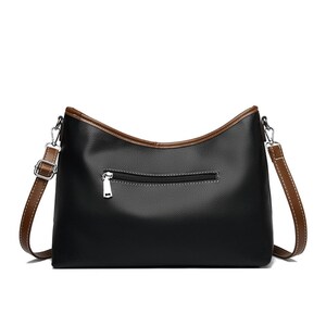 Pu&ograve; includere: Borsa a tracolla nera con finiture e cinturino marroni. La borsa ha una chiusura a cerniera sul retro e una chiusura in metallo color argento. La borsa &egrave; realizzata in un materiale liscio simile alla pelle.