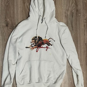 May include: A white ceramic mug with a black handle and the text "But First, Coffee" in a black, bold font. The mug is on a white surface. The mug is approximately 4 inches tall.