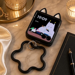 May include: Black phone case with cat ears, displaying a cartoon image of a cat eating sushi. A black, flower-shaped phone grip is attached. The phone screen shows the time 19:09 and a battery level of 64%.
