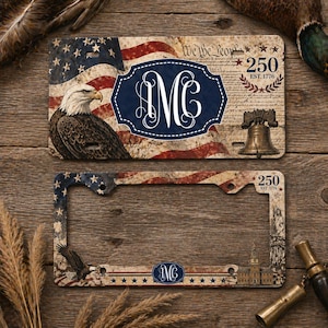 May include: License plate and license plate frame with an American flag design, an eagle, and the text "We the People". The license plate features the initials "MC" in a navy blue oval. The frame has the text "250 EST. 1776".