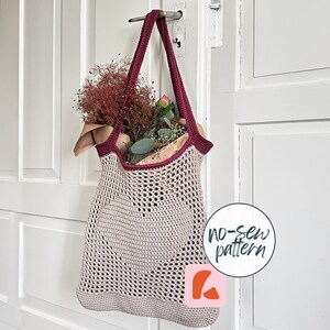 Könnte beinhalten: Eine beige Häkel-Tragetasche mit dunkelrotem Rand und Henkeln, die in der Mitte ein herzförmiges Muster aufweist. Die Tasche enthält einen Strauß aus getrockneten Blumen und Grünpflanzen. Eine kreisförmige Grafik mit dem Text no-sew pattern.