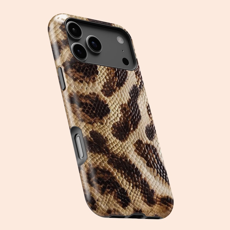 Op de afbeelding: Een smartphonehoesje met een slangenprint in bruin, beige en zwart. De hoes heeft een zwarte cameramodule en een zwart frame. De hoes is ontworpen om de telefoon te beschermen tegen krassen en beschadigingen.