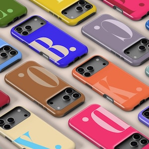 以下が含まれることがあります： さまざまな文字やデザインが施された、カラフルな携帯電話ケースのコレクション。ケースは青、緑、黄、ピンクなど様々な色があります。ケースはグリッド状に配置されており、様々なスタイルが紹介されています。