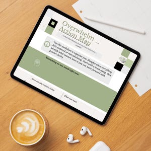 Peut inclure: Une tablette numérique affichant une feuille de travail "Overwhelm Action Map", conçue pour organiser les pensées. Sur une surface en bois, avec une tasse de café, des écouteurs sans fil et un crayon.