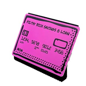 Op de afbeelding: Een roze creditcardontwerp met de tekst "FILTHY RICH SAVINGS & LOAN". De kaart heeft een zwarte rand en zwarte tekst, inclusief cijfers en het woord "MOM". De vervaldatum is 01/25.