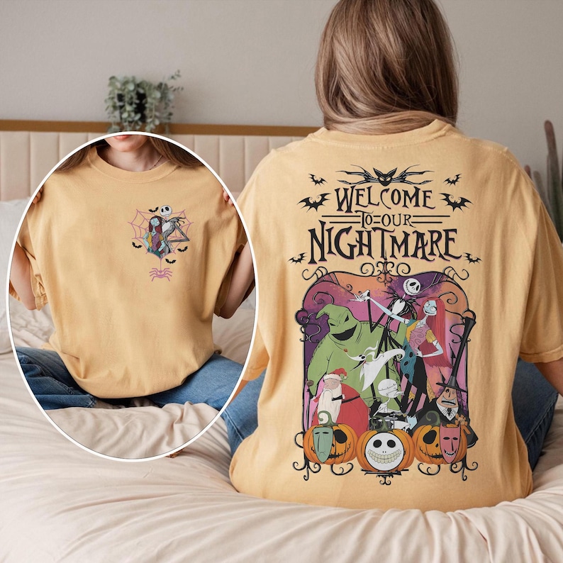 May include: Mustard-colored t-shirt featuring a graphic from "The Nightmare Before Christmas." The front has a small design of Jack and Sally in a spiderweb. The back has a larger design with the text "Welcome to our Nightmare" and characters from the movie.
