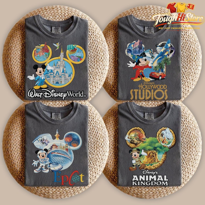 May include: Four gray t-shirts with Disney theme park designs. Each shirt features a Mickey Mouse head outline with park-specific graphics and text: "Walt Disney World," "Hollywood Studios," "Epcot," and "Animal Kingdom."