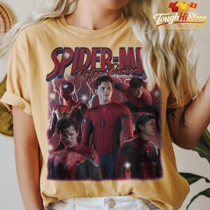 May include: Mustard yellow t-shirt featuring a graphic of Spider-Man with the text "SPIDER-MAN Peter Parker" in red and blue. The design includes multiple images of Spider-Man in various poses, with lightning bolt accents.