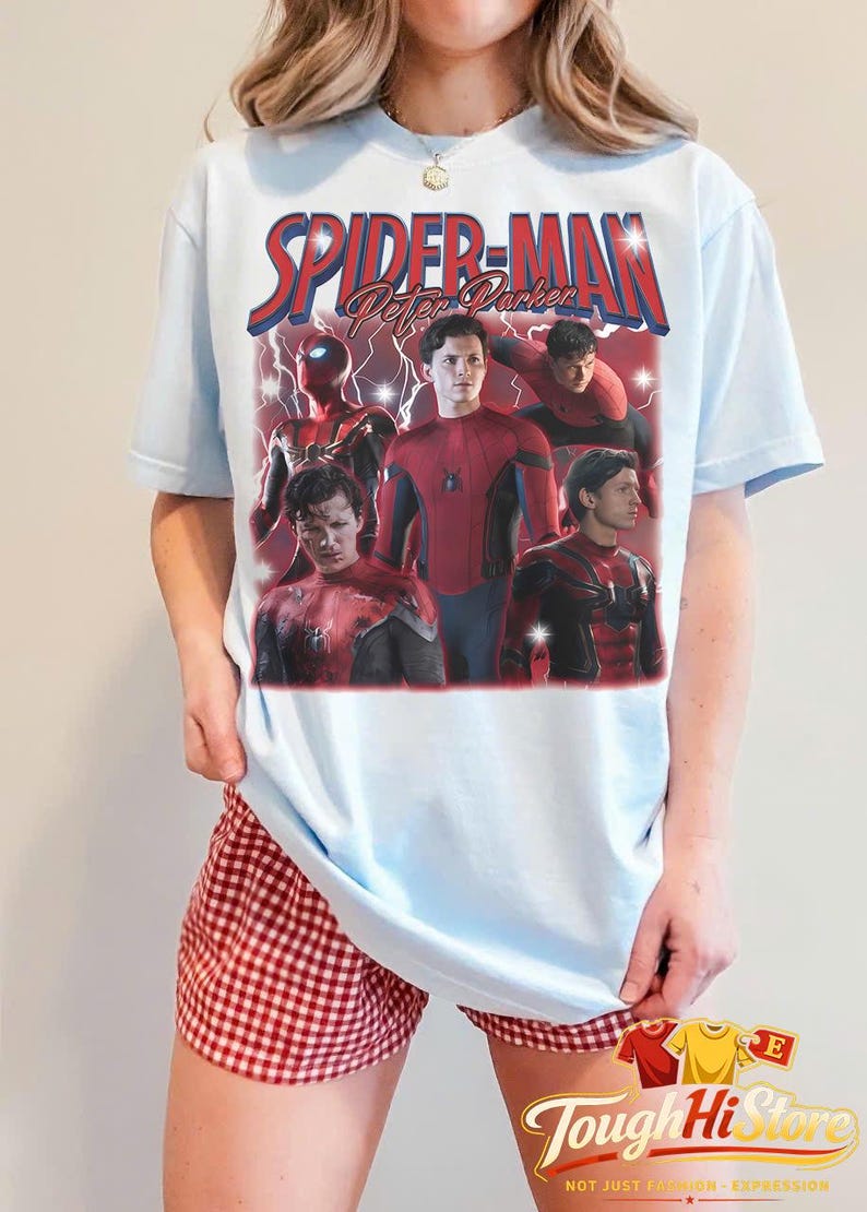 May include: Light blue t-shirt featuring a graphic of Spider-Man with the text "Spider-Man Peter Parker". The design includes multiple images of Spider-Man in his suit. The shirt is a light blue color.