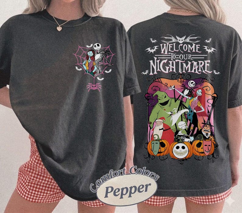 May include: Dark gray t-shirt featuring characters from The Nightmare Before Christmas. The front has Jack and Sally in a web, and the back says "Welcome to our Nightmare" with other characters and pumpkins. The shirt is a Comfort Colors Pepper.
