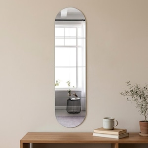 モダンなリビングスペースに最適な、ミニマルデザインの背の高い楕円形壁掛けミラー