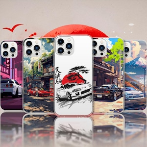 May include: A collection of phone cases with Japanese-inspired designs. Each case features a different illustration of cars, cityscapes, and a rising sun. The cases are in various colors, including red, white, blue, and green.
