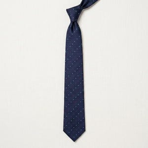 May include: Navy blue tie with a repeating pattern of small white and red dots. The tie is knotted at the top and hangs vertically against a white background. A classic accessory for formal or business attire.