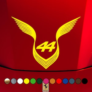 Pode incluir: Gráfico amarelo e vermelho com o número "44" dentro de um emblema alado, sobre um fundo vermelho. A imagem inclui uma paleta de cores na parte inferior e um logotipo "Ferrari".