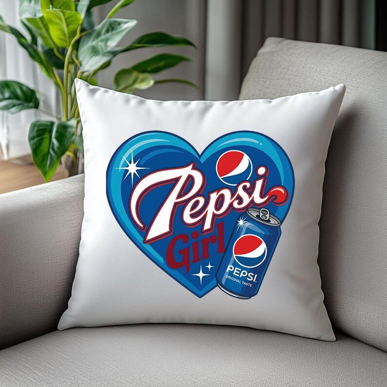 May include: A white square throw pillow featuring a large blue heart graphic. Inside the heart, the text Pepsi Girl is written in white and red script. A blue Pepsi soda can with the red, white, and blue logo is positioned on the lower right.