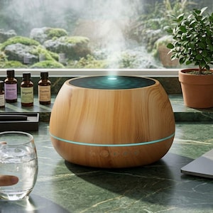 Puede incluir: Un difusor de aceites esenciales redondo con acabado de grano de madera que emite un chorro vertical de niebla. El dispositivo cuenta con una parte superior circular oscura, una banda LED azul claro y cinco botones de control.