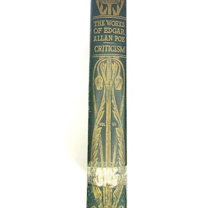 以下が含まれることがあります： 「The Works of Edgar Allan Poe Criticism」のタイトルが金色の文字で記された、濃い緑色の表紙のヴィンテージ本の背表紙。 金色の花柄模様と巻数VIIが特徴です。