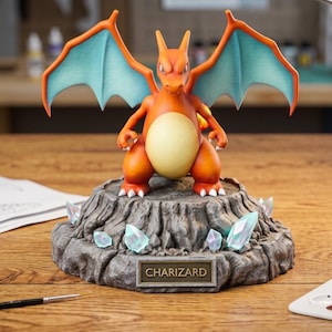 May include: A detailed Charizard figurine, orange with blue wings, stands on a rocky base with crystal accents. The base has a plaque that reads "CHARIZARD". The figurine is set on a wooden surface.