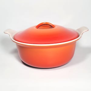 Peut inclure: Une cocotte orange vif avec un couvercle assorti. Le pot a deux poignées blanches et un bord blanc. Le couvercle comporte une petite poignée orange. Idéal pour cuisiner des ragoûts, des soupes et des casseroles.
