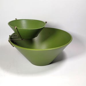May include: A two-tiered serving bowl set in a green colour. The top bowl is smaller and sits inside the larger bowl, which has a wider base.