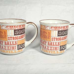 2 A La Carte Stoneware Mugs Japan for Giftcraft Browns Golds Rusts Food Names