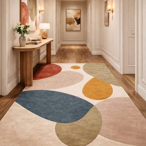 Handmade abstract wool rug with scalloped edges featuring organic shapes in rust, beige, ivory, grey, and charcoal tones on wooden floor in modern living room setting