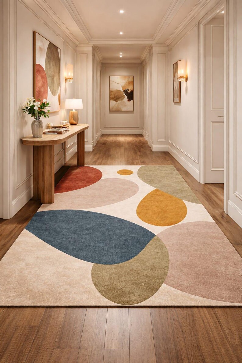 Handmade abstract wool rug with scalloped edges featuring organic shapes in rust, beige, ivory, grey, and charcoal tones on wooden floor in modern living room setting
