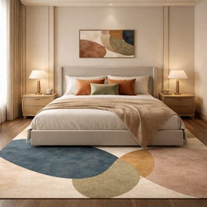 Handmade abstract wool rug with scalloped edges featuring organic shapes in rust, beige, ivory, grey, and charcoal tones on wooden floor in modern living room setting