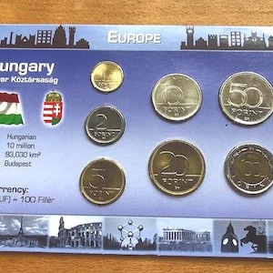 May include: A souvenir card featuring Hungarian coins and a flag. The card is labeled "Hungary" and "Europe." The card includes information about the language, population, area, and capital. The coins are in various denominations.