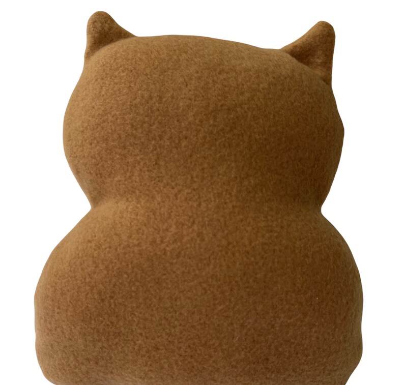 May include: A brown plush toy shaped like an owl with large ears. The owl is made of soft, fuzzy fabric.