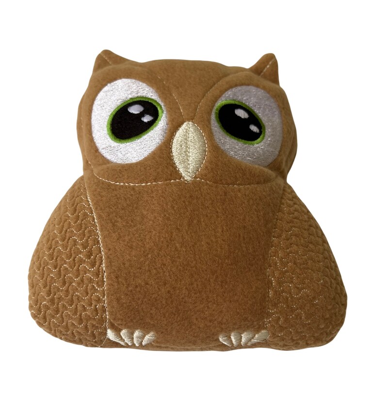 May include: A brown plush owl with embroidered eyes and a textured pattern. The owl has a white beak and white feet.