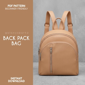 Könnte beinhalten: Ein beigefarbener Rucksack mit rundem Design, mit einer Reißverschlusstasche vorne und verstellbaren Trägern. Die Tasche hat silberfarbene Reißverschlüsse und einen oberen Griff. Auf der linken Seite steht "PDF PATTERN BEGINNER FRIENDLY", "BACK PACK BAG" und "INSTANT DOWNLOAD".