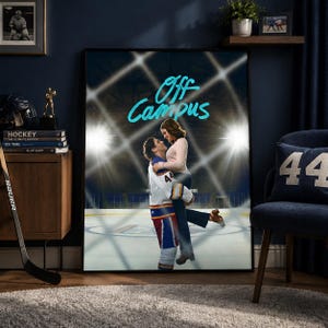 Op de afbeelding: Een ingelijste poster met een stel dat elkaar omhelst op een ijsbaan, met de woorden "Off Campus" in turquoise. De man draagt een hockey-uniform en de vrouw een roze trui. De achtergrond toont stadionlichten.