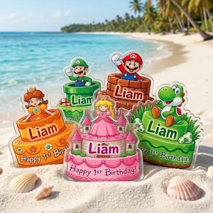 May include: Five acrylic cake toppers featuring Super Mario characters including Princess Daisy, Luigi, Mario, Princess Peach, and Yoshi. Each topper displays the name Liam and the text Happy 1st Birthday on colorful cake or castle designs.