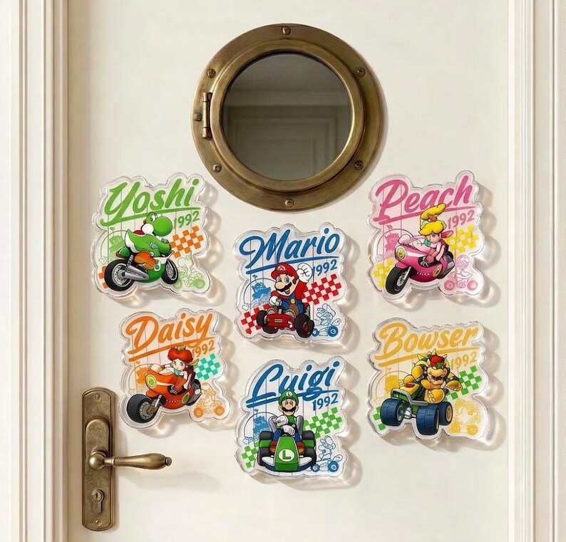 Peut inclure: Six autocollants en acrylique transparent repr&eacute;sentant les personnages de Nintendo Yoshi, Mario, Peach, Daisy, Luigi et Bowser sur leurs v&eacute;hicules. Chaque autocollant inclut le nom, l'ann&eacute;e 1992 et un motif de drapeau &agrave; damier sur une porte blanche.