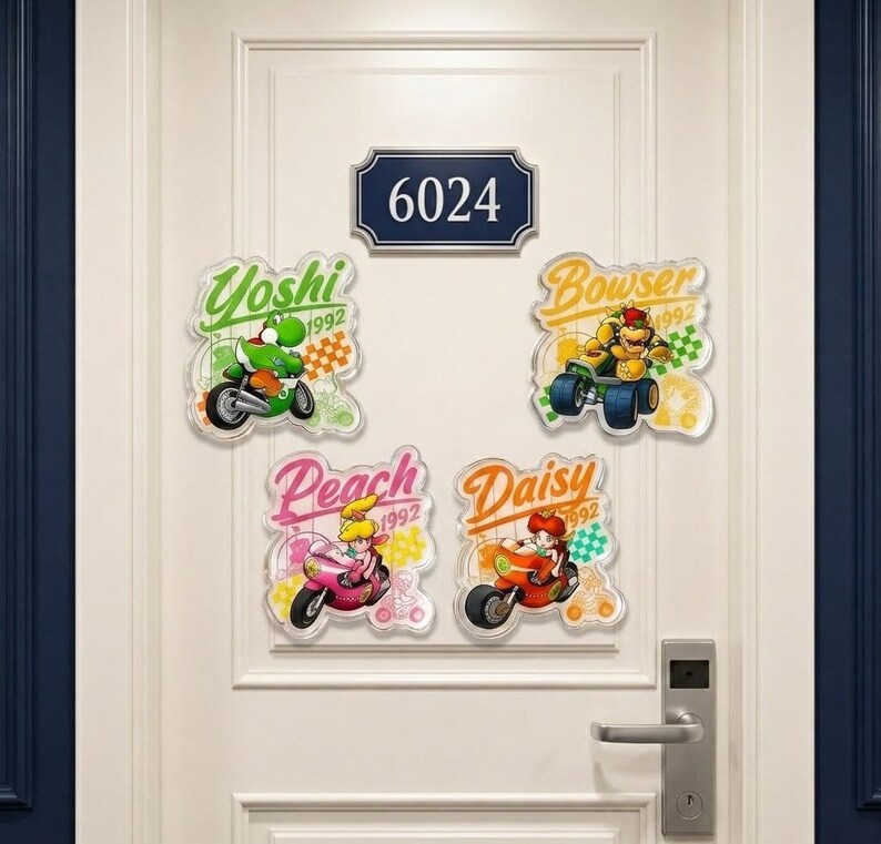 Peut inclure: Quatre autocollants muraux d&eacute;coratifs repr&eacute;sentant les personnages Nintendo Yoshi, Bowser, Peach et Daisy sur des karts ou des motos, chacun avec leur nom et l'ann&eacute;e 1992 imprim&eacute;s dans une police stylis&eacute;e, dispos&eacute;s sous une plaque rectangulaire 6024.