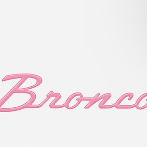 May include: A pink script-style emblem featuring the word Bronco in a cursive font. The lettering has a raised, three-dimensional appearance with smooth, rounded edges, set against a plain, solid white background.