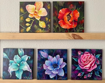 May include: Five square floral paintings on a wooden shelf. The paintings feature close-up views of an orange orchid, a red poppy, a turquoise lily, a blue lotus, and a pink rose. Each painting has a dark background.