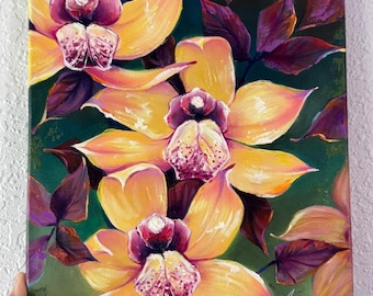 May include: A rectangular canvas painting featuring three large yellow orchids with deep purple centers and speckled petals. The flowers are surrounded by dark purple and green foliage against a dark green background. The artist's signature is in the corner.