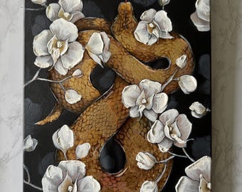 May include: A rectangular canvas painting featuring a textured golden-brown snake coiled in a figure-eight shape against a black background. The snake is surrounded by numerous white orchid flowers with visible brushstrokes and a small red tongue.
