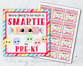 May include: A colourful printable card with the text "You're going to be such a SMARTIE in PRE-K!" The card features a cartoon sweet with a smiling face and rainbow stripes. There are also several smaller cartoon sweets with smiling faces.