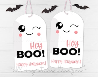 Pode incluir: Duas etiquetas de presente brancas em forma de fantasma com bochechas cor-de-rosa e olhos pretos. O texto nas etiquetas diz "Hey BOO! Happy Halloween!"