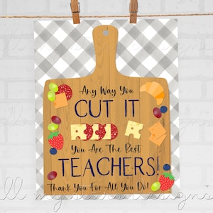 Puede incluir: Una tabla de cortar de madera marrón con un fondo a cuadros. La tabla tiene varios alimentos sobre ella, incluyendo queso, salami, uvas y fresas. El texto en la tabla dice "Any Way You CUT IT You Are The Best TEACHERS! Thank You For All You Do!"