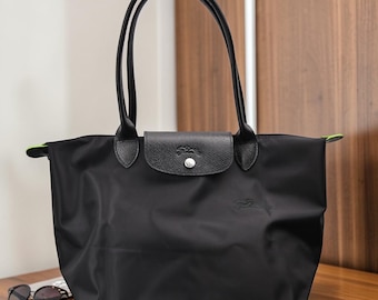 Bolso tote Longchamp de nailon negro, grande, ligero y plegable con ribete de piel, ideal para llevar al hombro a diario y para viajes de diseño.