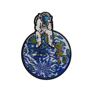 May include: Embroidered patch featuring a white astronaut sitting on a blue and green Earth. The astronaut is wearing a white spacesuit with a blue visor. The Earth has detailed continents and oceans, with a black border.